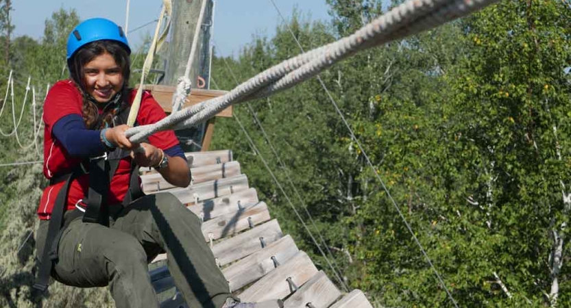 a student holds a rope while complete a ropes course with outward bound